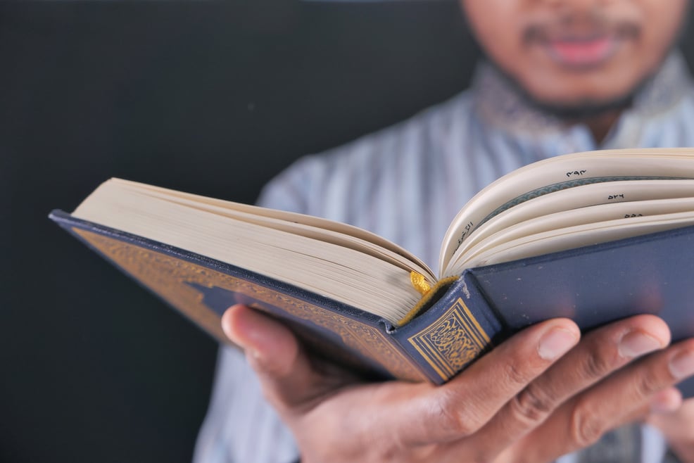 Muslim Mans Hand Reading Quran at Night